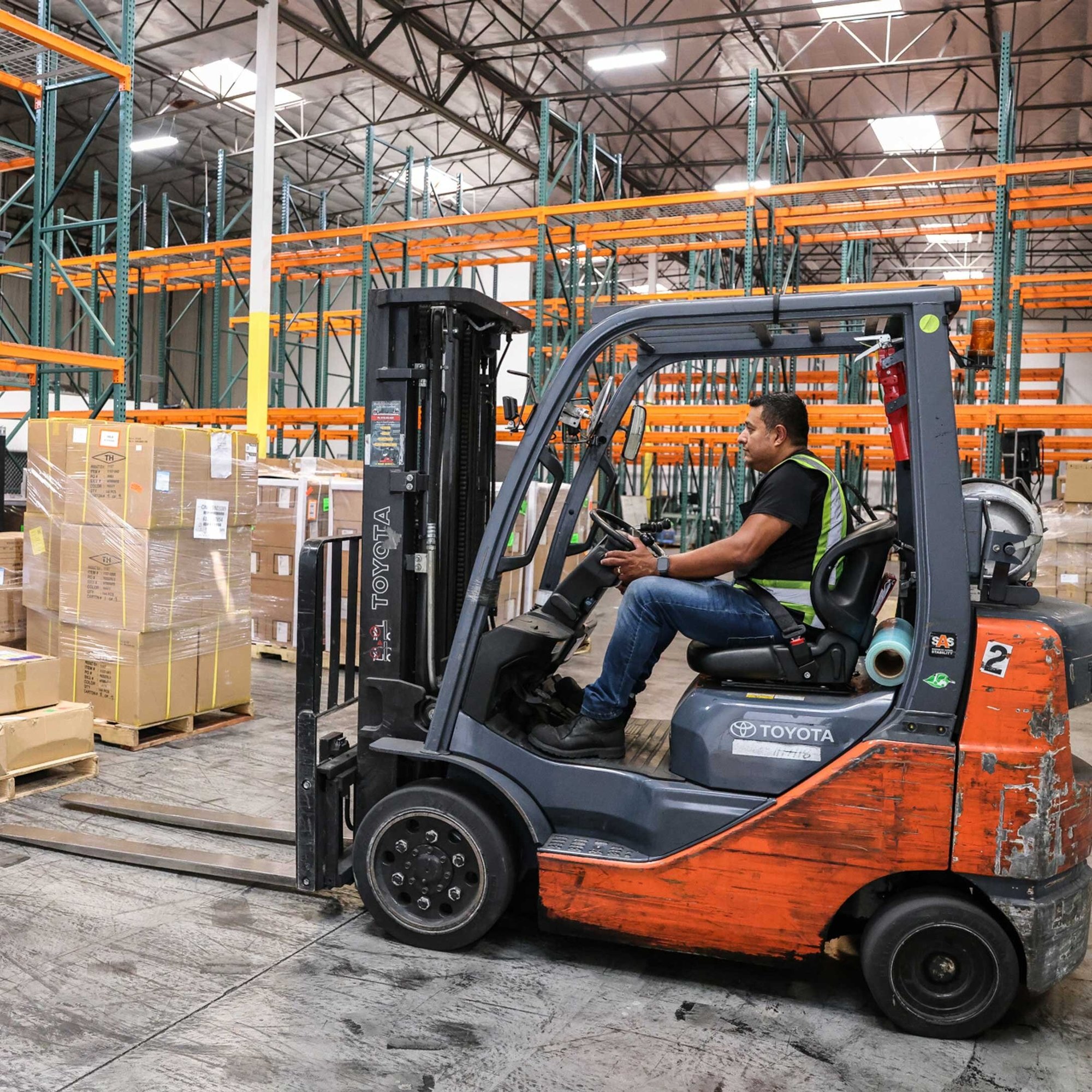 Worker Driving Forklift In Warehouse